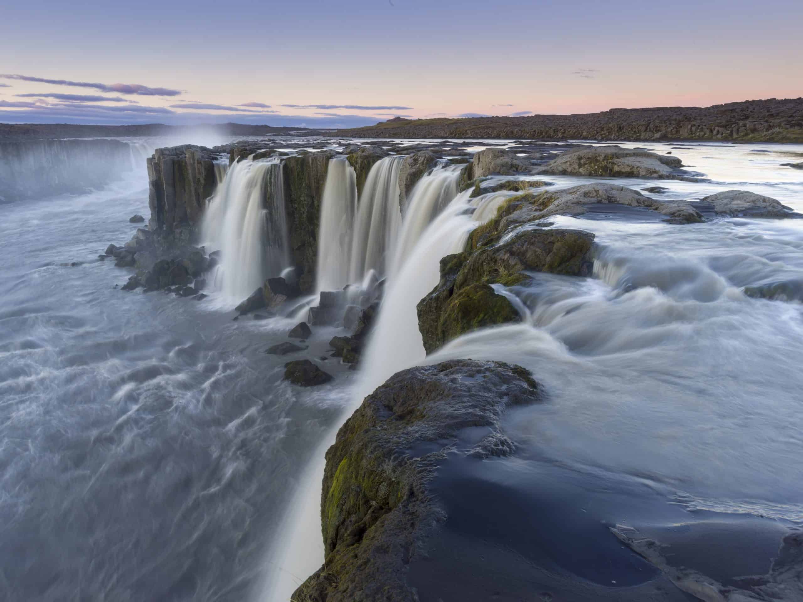 an image showing a large waterfall flowing into a body of water